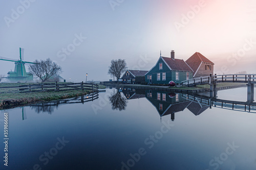 Reflection of a Dutch wooden rural house on a calm canal water nearby Amsterdam