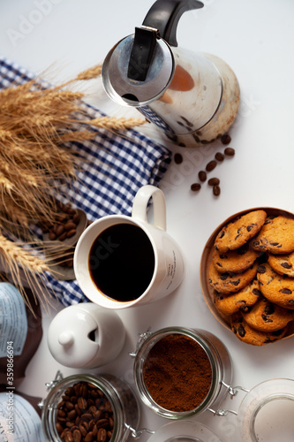 Still life with a coffee maker and cookies. Breakfast top view. Coffee grains poured from a can on kitchen table. Coffee cup mood. Coffee bean, Food background. © Real_life