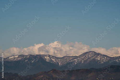 View of the foothills of the Caucasus. High peaks are covered with snow. Mountains against the blue sky. Day. Sunny. Georgia. © Viktor