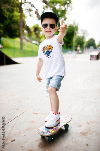 Boy with a skate in a skate park. A boy with glasses learns to skate.