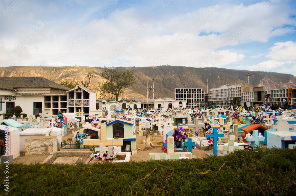 QUITO, ECUADOR- MAY 23, 2017: View of cemetery San Antonio de Pichincha, showing typical catholic graves with large gravestones, mountain background