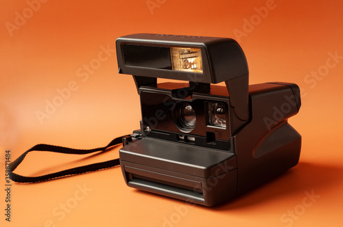 Vintage photo camera on orange background