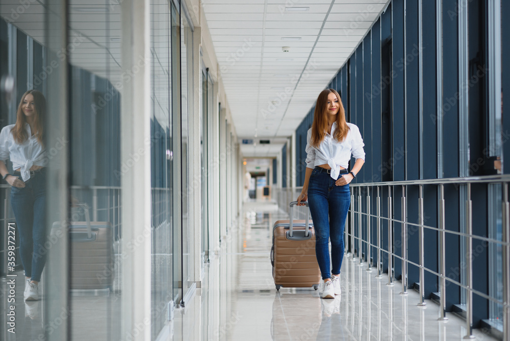 pretty girl with a suitcase in the airport terminal. vacation and travel concept pretty girl with a suitcase in the airport terminal. vacation and travel concept