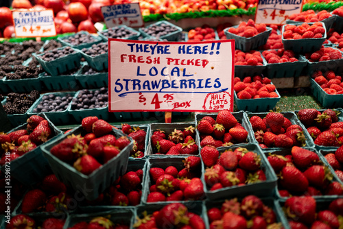 Red Strawberries and a sign at a fruit farmers market fruit stand in Seattle Washington