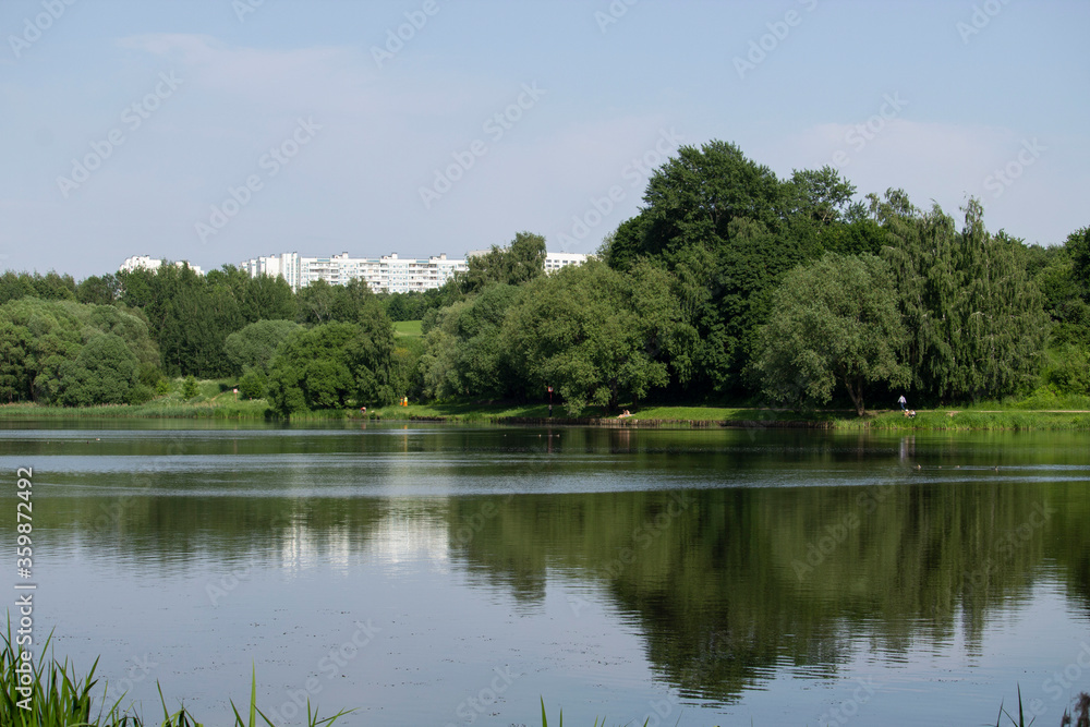 Multistorey building in the park on the bank of the river Multistorey building in the park on the bank of the river