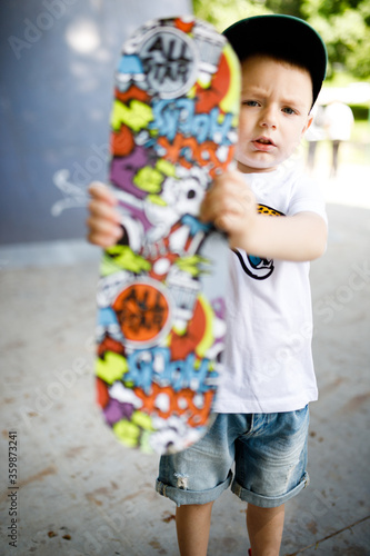 Boy with a skate in a skate park. A boy with glasses learns to skate.