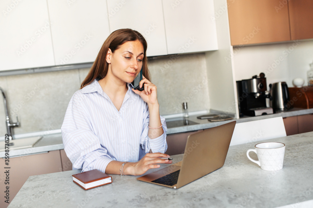 Responsible woman answers phone calls, takes online orders from store intranet working remotely from home. Distance work concept Responsible woman answers phone calls, takes online orders from store intranet working remotely from home. Distance work concept