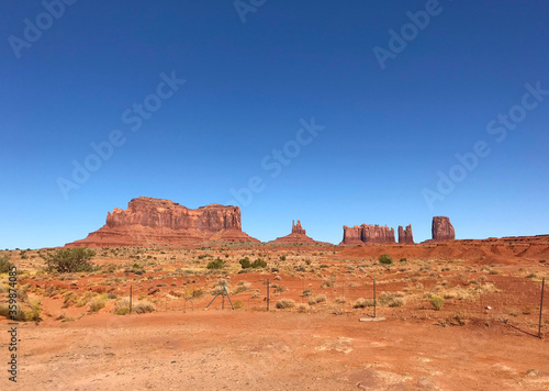 Amazing view of Monument Valley with red desert and blue sky and clouds in the morning. Monument Valley in Arizona with West Mitten Butte, East Mitten Butte, and Merrick Butte. 