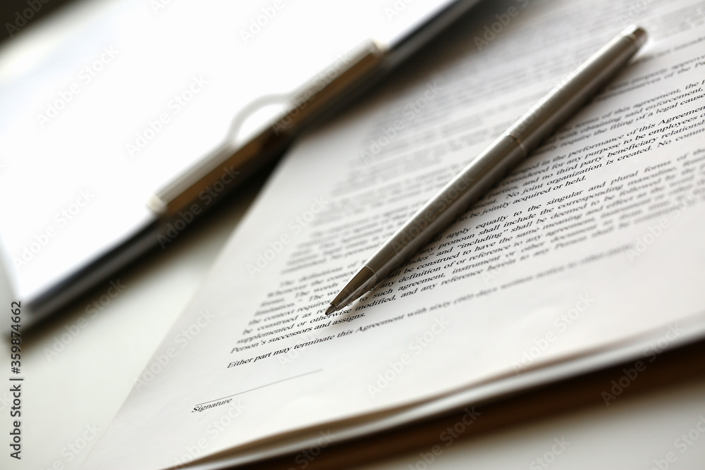 Close up of stylish ball pen, clipboard and contract with line for signature Close up of stylish ball pen, clipboard and contract with line for signature