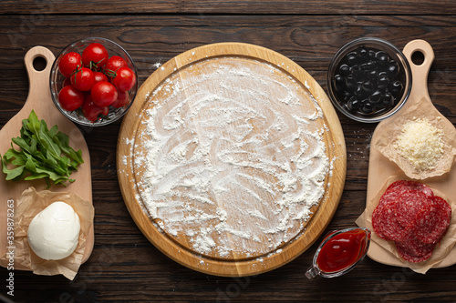 Process of making homemade pizza with mozzarella olives and salami, top view photo