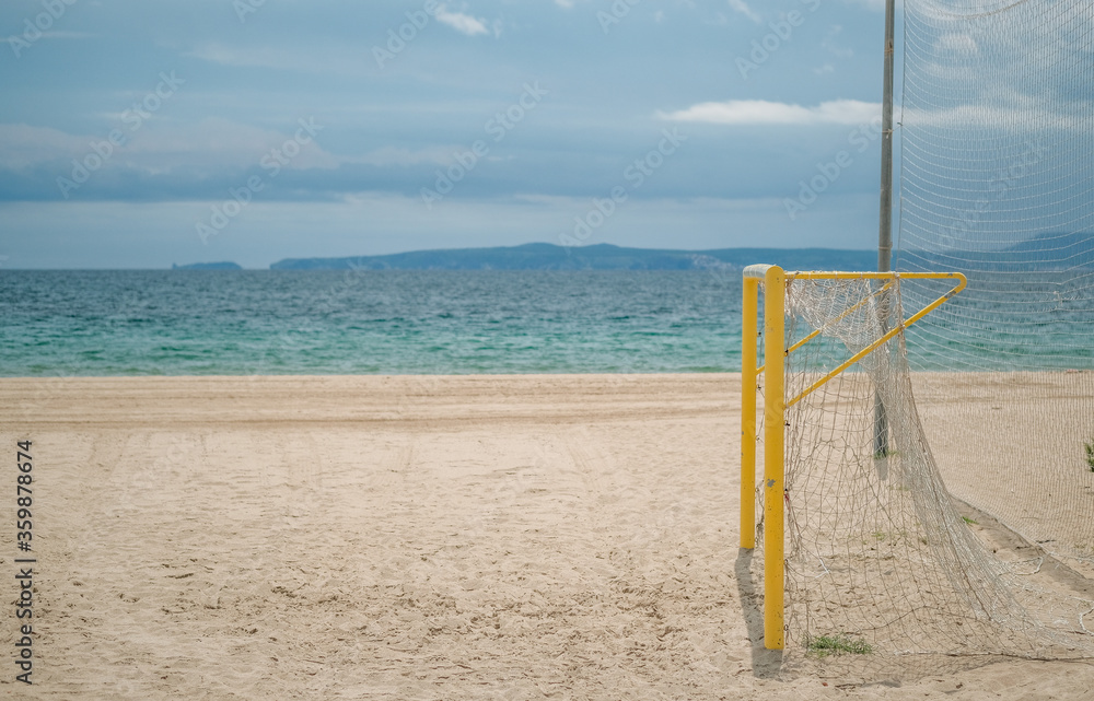 Empty beach with football goal on a sunny day on the sea and blue sky background. Preparing the beach for the game. Roses, Catalunya, Spain.