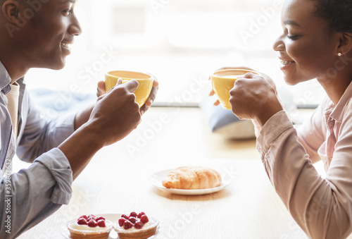 Loving black couple meeting for date at coffee shop