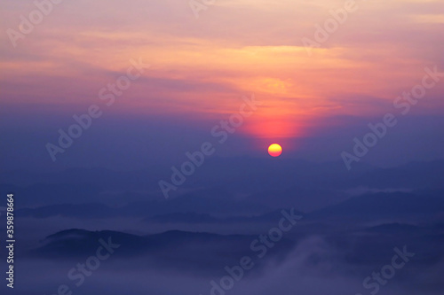 Sunset over the mountain view with lot of mist