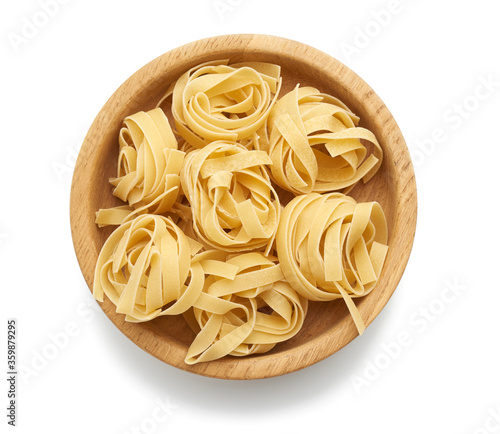 twisted pasta in round fettuccine nests on a wooden plate