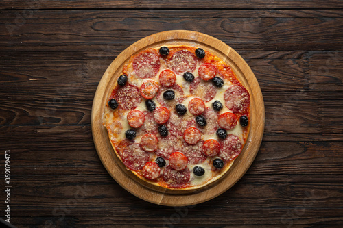 Process of making homemade pizza with mozzarella olives and salami, top view photo