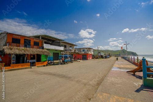 MANABI, ECUADOR - JUNE 4, 2012: Stoned pavement road in the coast, surrounded with abundat vegetation in a sunny day in the Ecuadorian coasts