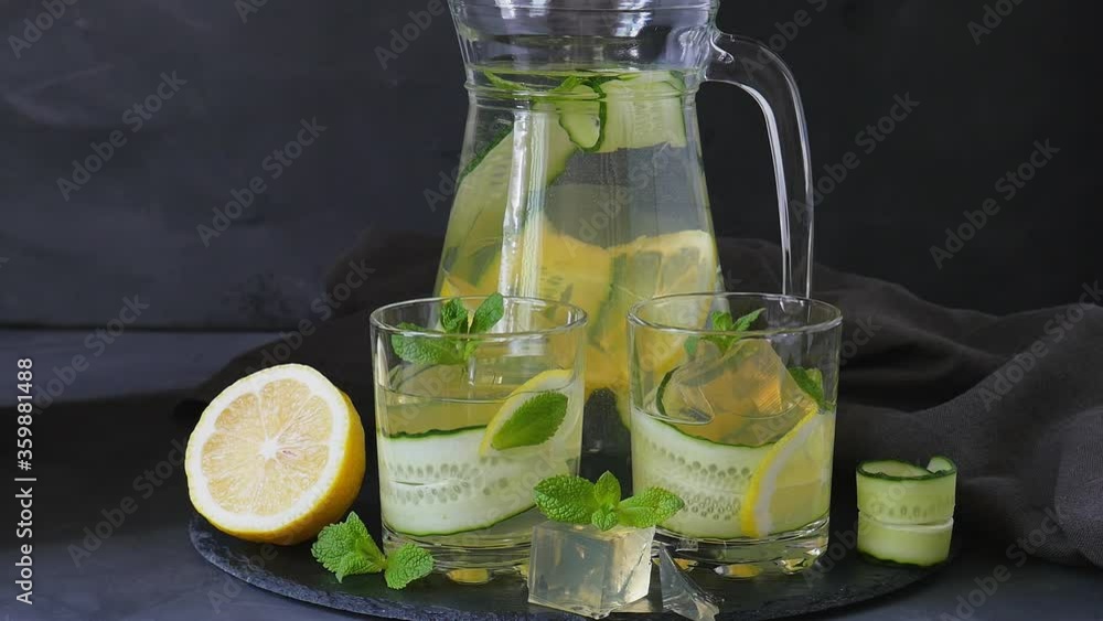 Lemon drink with cucumber and mint. Cooling drink. Pour a drink into a glass Lemon drink with cucumber and mint. Cooling drink. Pour a drink into a glass