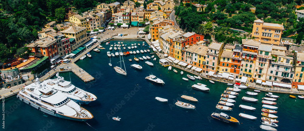 Aerial top view of sea bay with beautiful picturesque village called Portofino. .Small marina port with moored boats and yachts at the foot of mountain with a beautiful colourful houses village