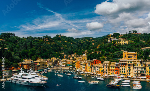 Aerial view of sea bay with beautiful picturesque village called Portofino, famous touristic destination. .Small marina port at the foot of mountain with a beautiful colourful houses village