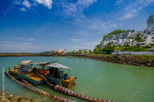 MANABI, ECUADOR - JUNE 4, 2012: Close up of a water pumping machine in a stagnant water with a at Same, Ecuador in a beautiful blue sky in a sunny day photo