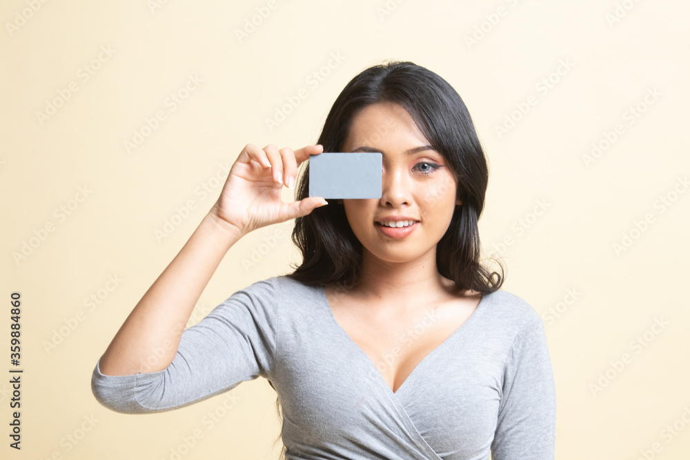 Young Asian woman with blank card over her eye. Young Asian woman with blank card over her eye.