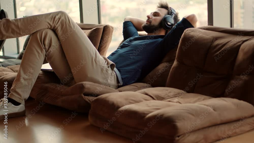 Happy Healthy Stress Free Man Relaxing In Office And Listening To Music.Employee Taking Break On Work.Businessman Leisure In Headphone.Successful Serious Man Sitting On Workplace And Listening Podcast