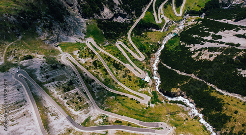 Bird's eye view of famous Stelvio Pass mountains serpentine way. Top view of scenic curvy hairpins in picturesquely mountainous terrain of Italy. Panoramic highway road with high elevation photo