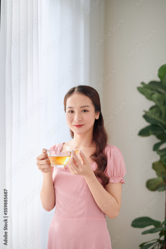 Young woman with glass of water taking vitamin pill at home Young woman with glass of water taking vitamin pill at home