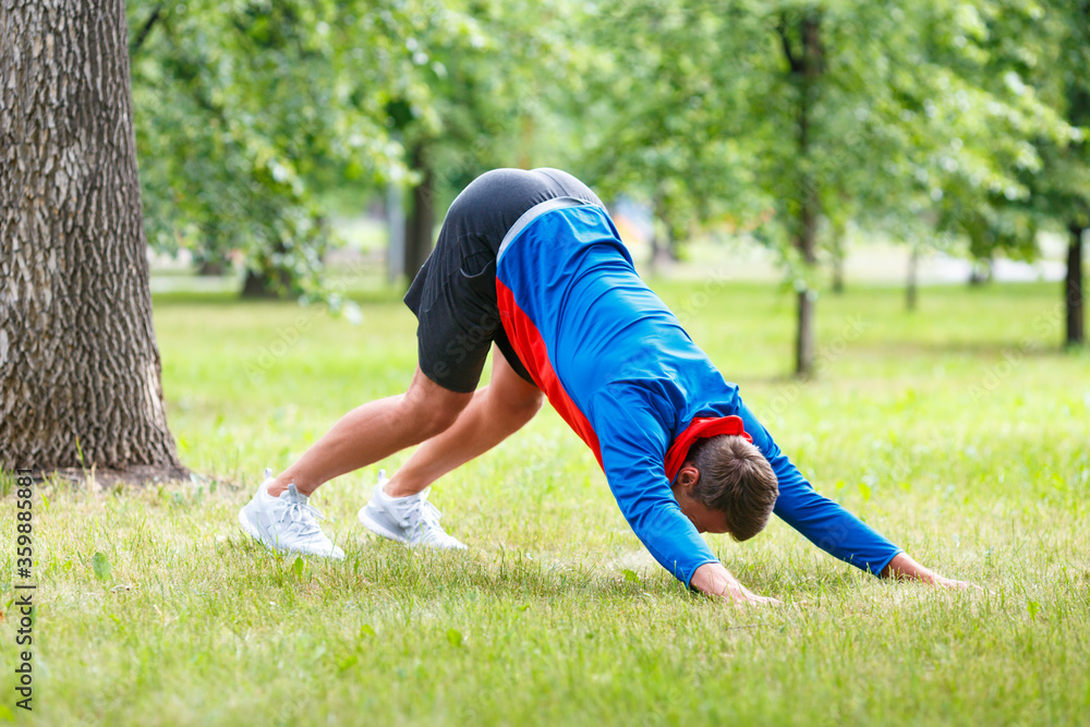 Man practice yoga in park. Adult man do downward facing dog pose. Man practice yoga in park. Adult man do downward facing dog pose.