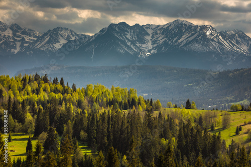 Spring in the Tatra Mountains. Green fields against the backdrop of snowy peaks. Landscape photo from Lesser Poland.