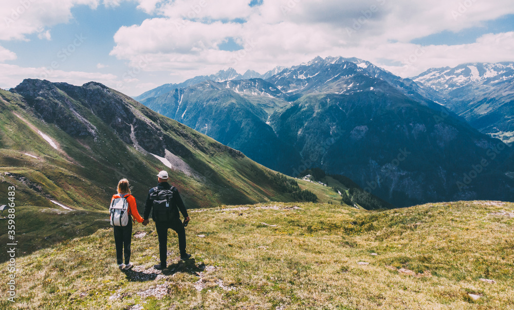 Romantic couple of backpackers standing on mountain top and enjoying beauty of nature during vacations. Man and woman wanderlusts with rucksacks exploring scenery places traveling in National Parks