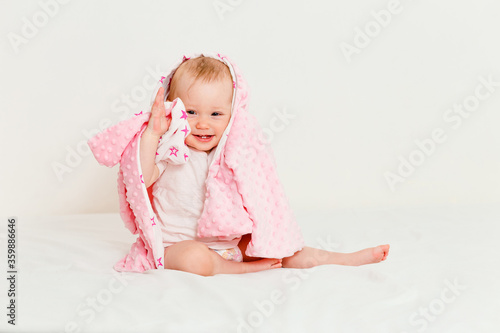 Smiling little girl sits on the bed