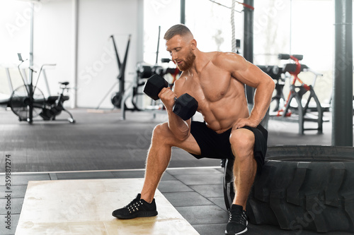 Slika na platnu Gym athlete bicep exercise dumbbell muscular man sit wheel holding lift barbell