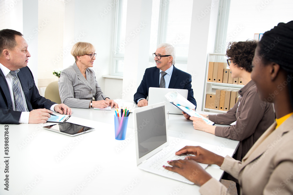 International group of business people working and communicating sitting near office desk. International group of business people working and communicating sitting near office desk.