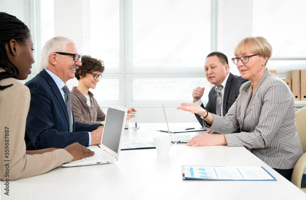 International group of business people working and communicating sitting near office desk. International group of business people working and communicating sitting near office desk.