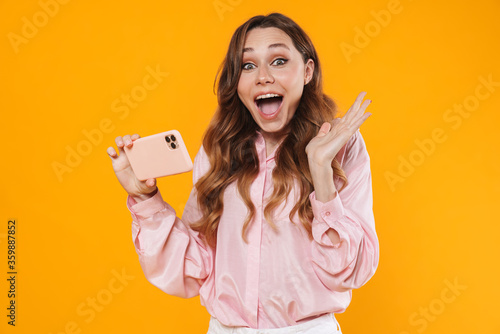 Image of delighted woman expressing surprise and using mobile phone © Drobot Dean