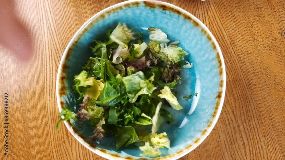 Falling salad in slow motion. Chef puts green leaves of salad in the plate. Falling salad in slow motion. Chef puts green leaves of salad in the plate.