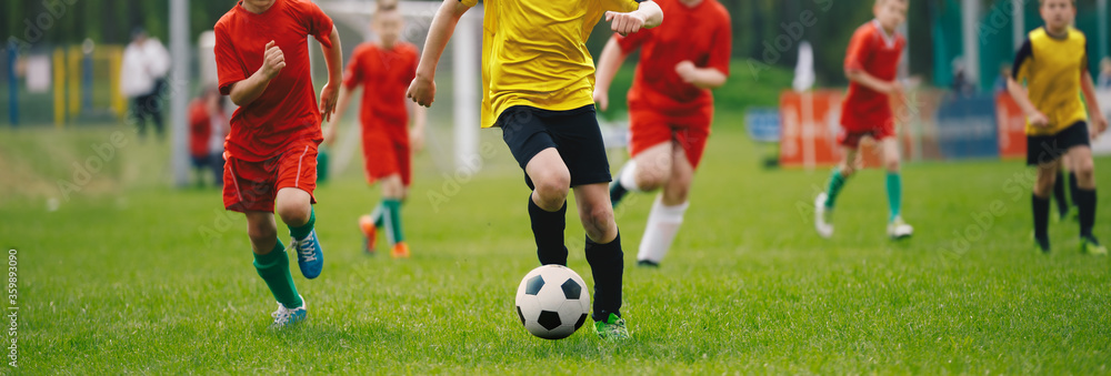 Soccer Players in Run. Young Boys Running After Ball During Football Tournament Match. Sports School Competition for Children. Junior Level Soccer Game. Players in Red and Yellow Jersey Sport Clothing Soccer Players in Run. Young Boys Running After Ball During Football Tournament Match. Sports School Competition for Children. Junior Level Soccer Game. Players in Red and Yellow Jersey Sport Clothing