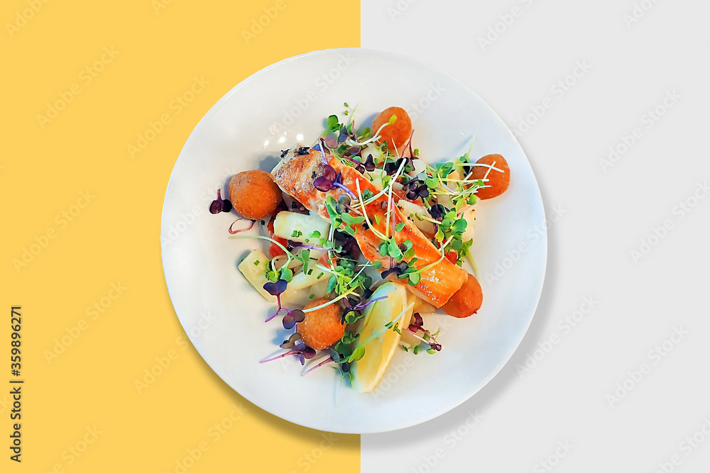 grill salmon steak with many mixed kind of fresh vegetables and lemon served on white plate dish isolated grill salmon steak with many mixed kind of fresh vegetables and lemon served on white plate dish isolated