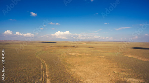 Top view aerial photo from drone of off road way with tires of car in arid dessert valley landscape. Beautiful nature view with copy space area. Concept of freedom of choice of destination in travel