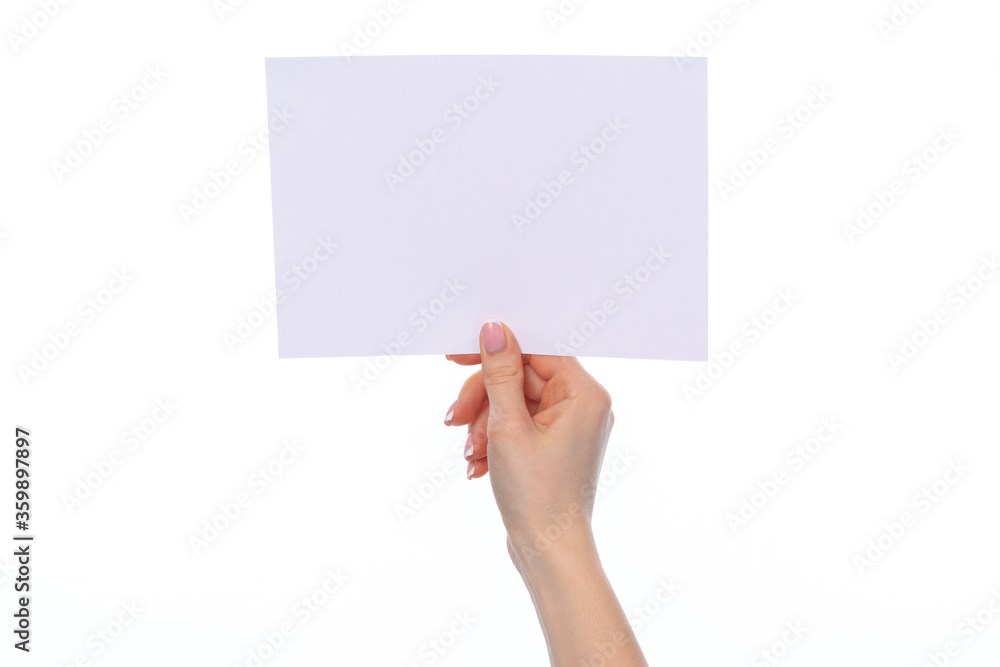 Obraz premium Female hand holding blank white sheet of paper isolated on white