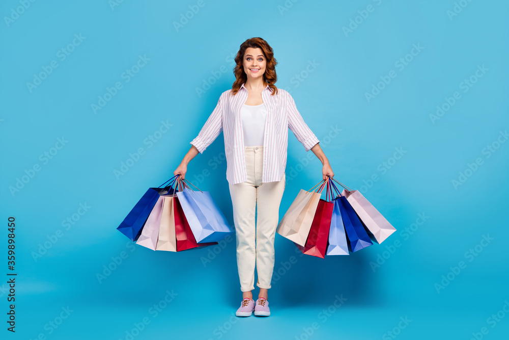 Full length body size view of her she nice attractive lovely cute pretty cheerful cheery wavy-haired girl carrying new things isolated on bright vivid shine vibrant blue color background Full length body size view of her she nice attractive lovely cute pretty cheerful cheery wavy-haired girl carrying new things isolated on bright vivid shine vibrant blue color background