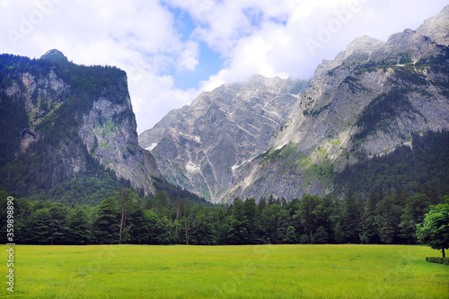 large green grass field with snow mountain view at Konigssee lake in Salzburg Germany