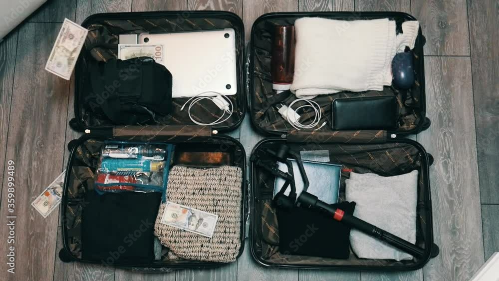 Money dollars are falling into a suitcase, Two suitcases are opened and filled with clothes. Time to travel. Journey Money dollars are falling into a suitcase, Two suitcases are opened and filled with clothes. Time to travel. Journey