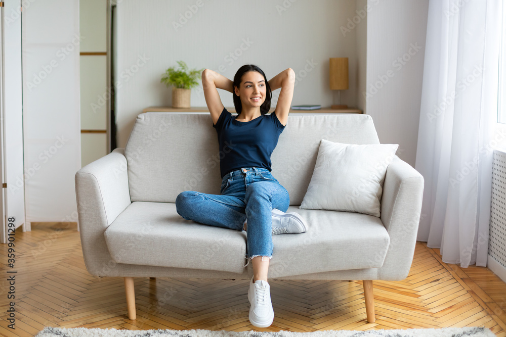 Girl Resting Holding Hands Behind Head Sitting On Sofa Indoors Girl Resting Holding Hands Behind Head Sitting On Sofa Indoors
