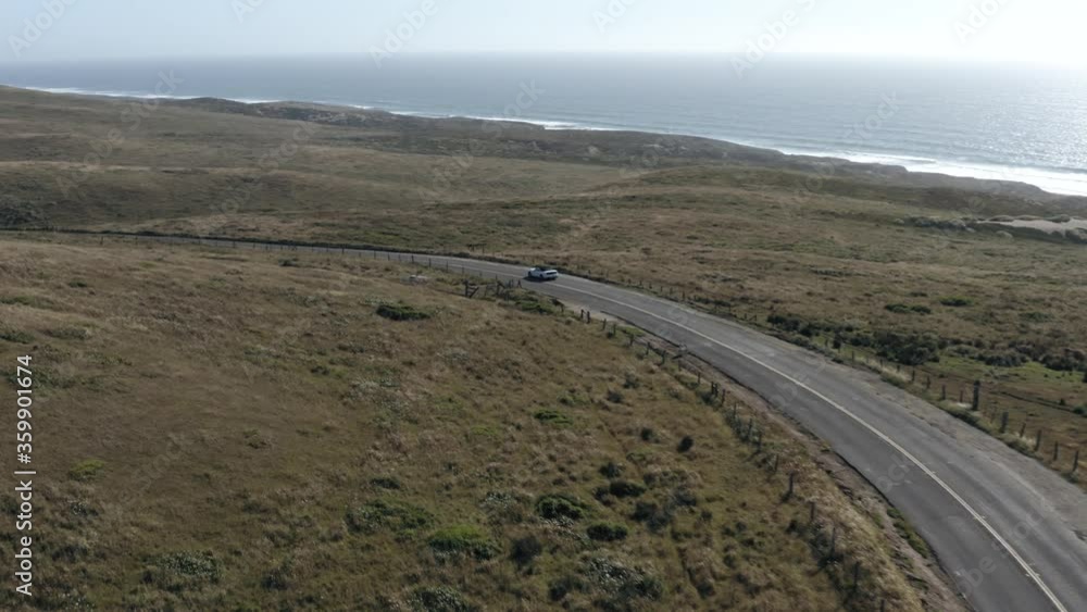Aerial tracking shot of car driving on Point Reyes panoramic highway Aerial tracking shot of car driving on Point Reyes panoramic highway