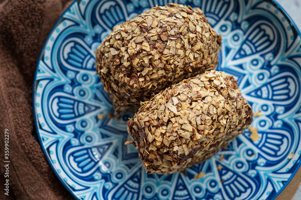 Bomboloni coated with oats. Donut filled with melted chocolate and eaten as a snack. Bomboloni originated from italy. Bomboloni coated with oats. Donut filled with melted chocolate and eaten as a snack. Bomboloni originated from italy.