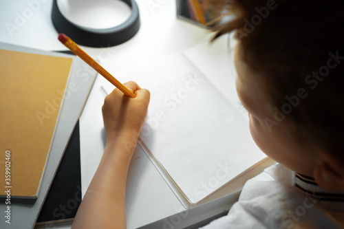 Little boy writing something in his notebook