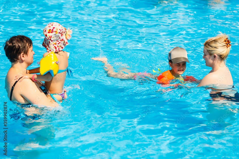 two women and their children in the pool