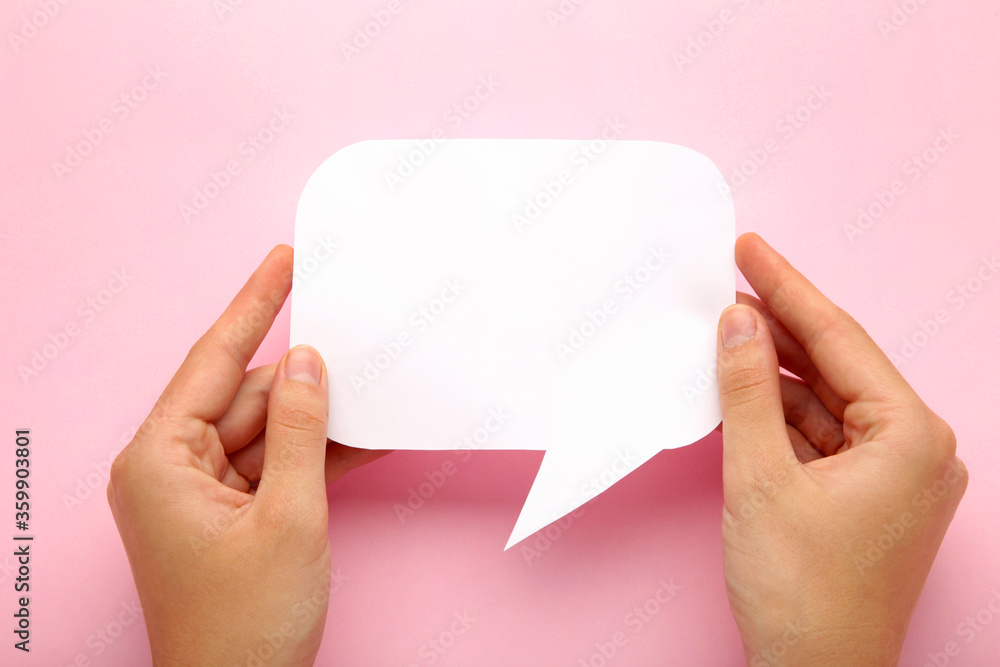 Obraz premium Hand holding an white empty speech bubble on pink background
